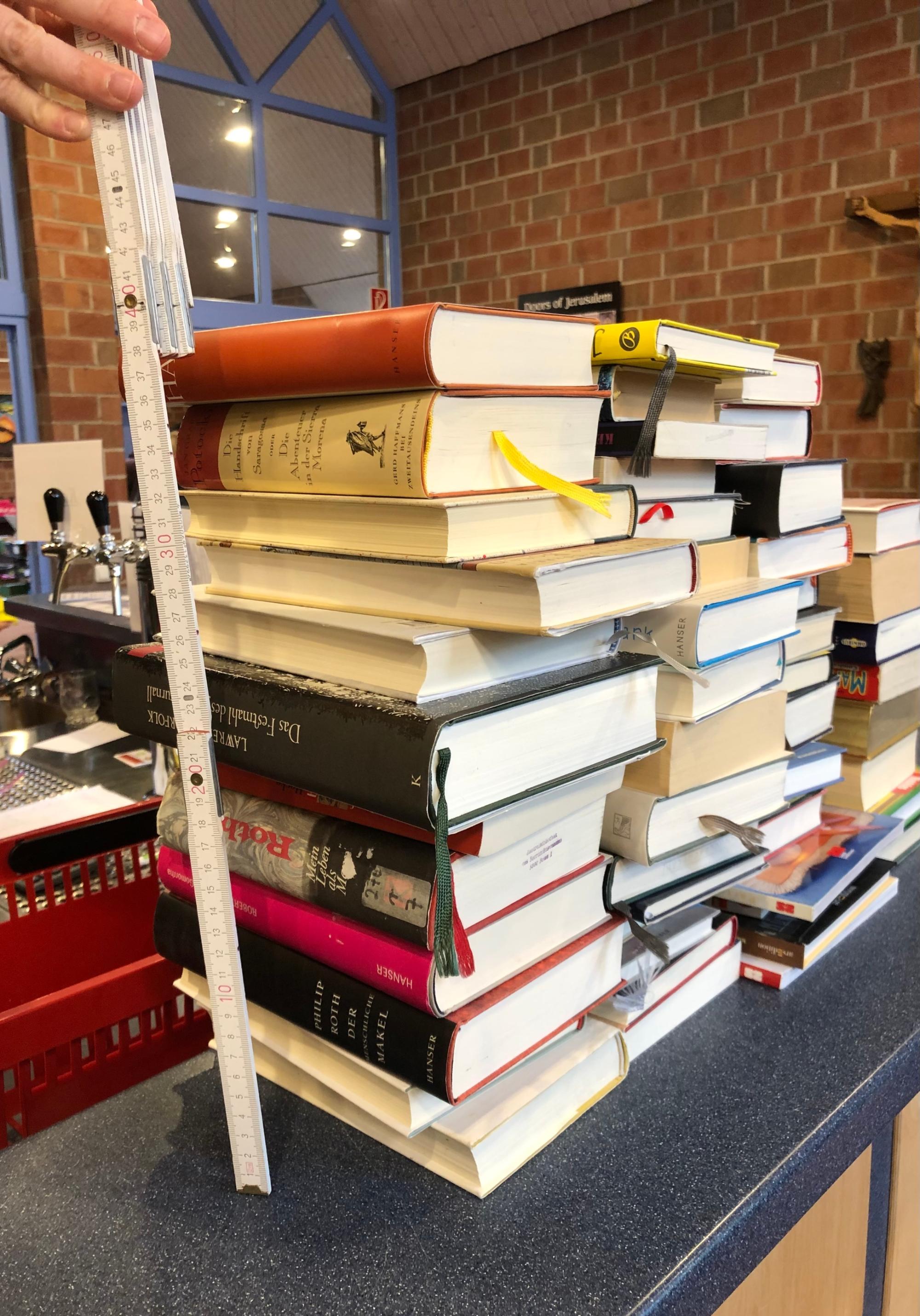 Bücherstapel wird gemessen.